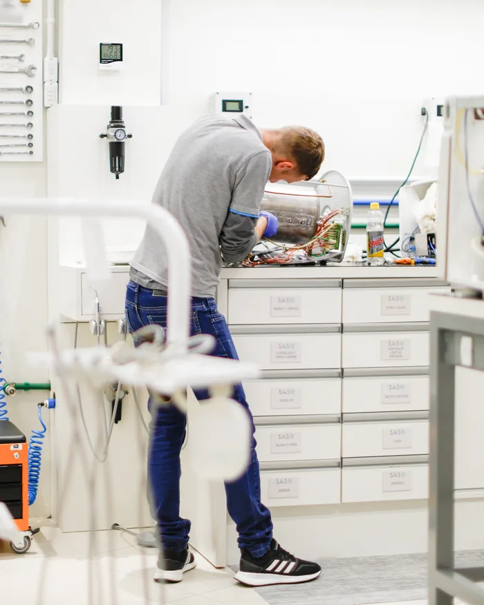 Técnico da SAS fazendo manutenção de equipamento no laboratório próprio